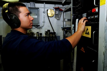 US Navy 091204-N-3038W-012 Aviation Structural Mechanic Airman Brian Caugvikan, inspects a test bench in the hydraulics shop aboard the aircraft carrier USS Nimitz (CVN 68)