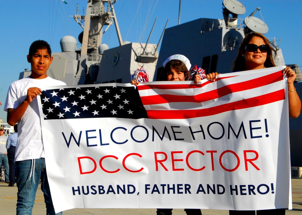 US Navy 091204-N-0209M-001 Family members and friends hold up signs as USS Wayne E. Meyer (DDG 108) arrives at its new homeport of San Diego
