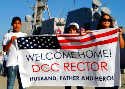 US Navy 091204-N-0209M-001 Family members and friends hold up signs as USS Wayne E. Meyer (DDG 108) arrives at its new homeport of San Diego