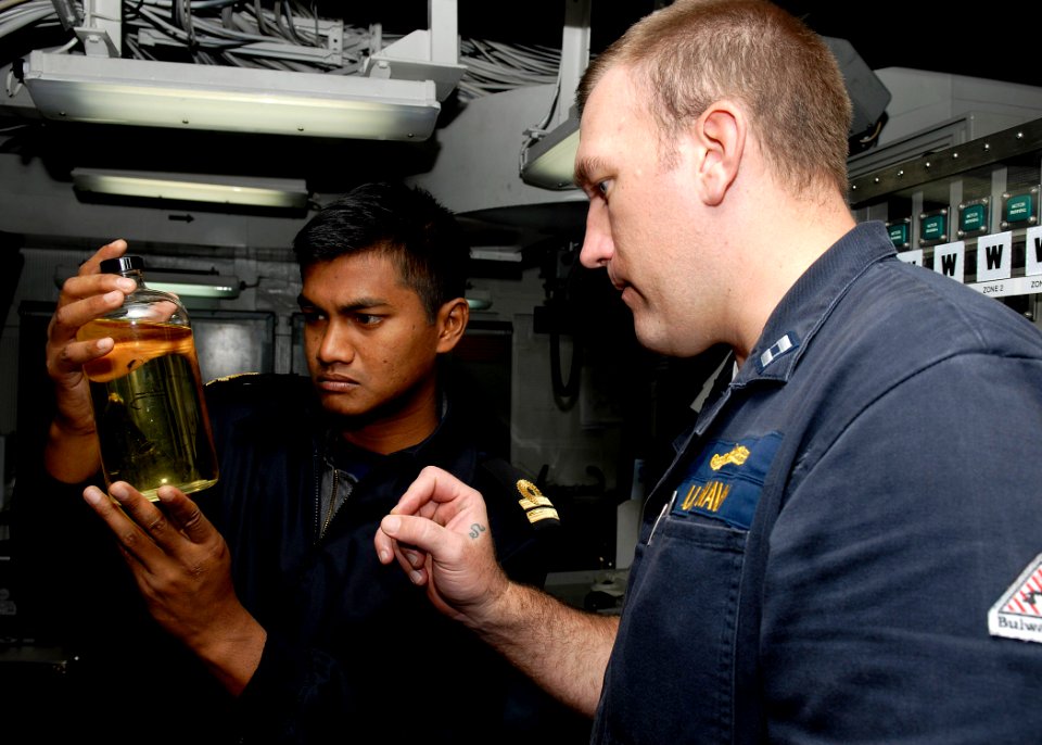 US Navy 091206-N-9520G-028 Lt. Jake Faulds shows a sample of F76 fuel to Lt. Yusri of the Royal Malaysian Navy