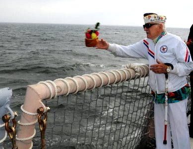 US Navy 091207-N-1522S-003 Pearl Harbor survivor Ed Kimic throws a bouquet of flowers overboard of the guided-milssile frigate USS Underwood (FFG 36) during a ceremony in remembrance of the lives lost on December 7, 1941