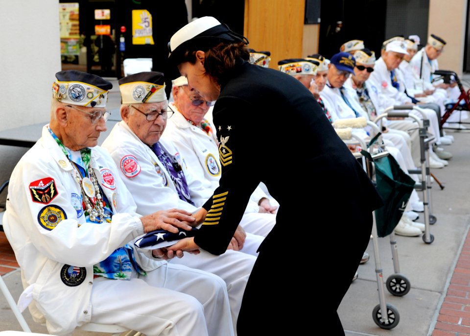 US Navy 091204-N-7032B-152 Command Master Chief Kathleen A. Hansen, assigned to Naval Medical Center San Diego, presents an American flag to retired Chief Electrician's Mate Stuart Hedley, a Pearl Harbor survivor