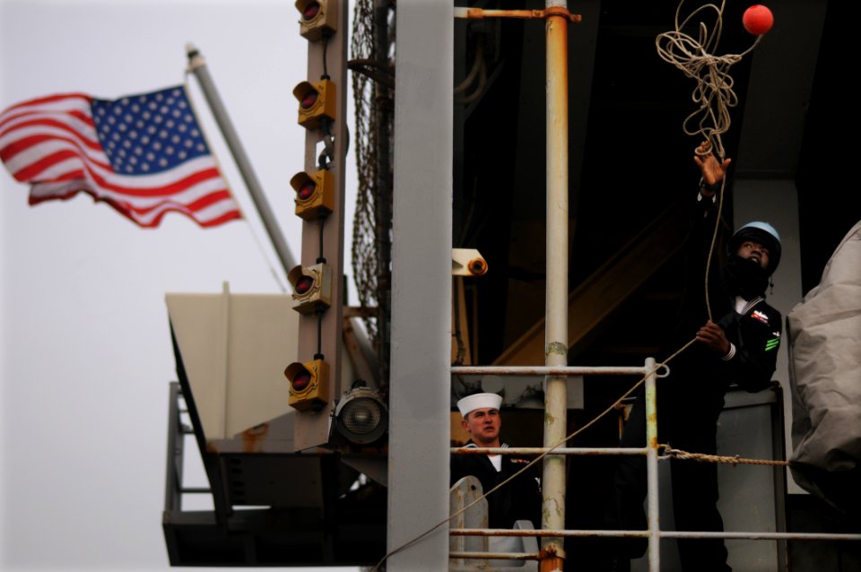 US Navy 091208-N-8907D-360 A line handler tosses a mooring line as the amphibious dock landing ship USS Fort McHenry (LSD 43) arrives in Little Creek, Va. after a seven-month deployment