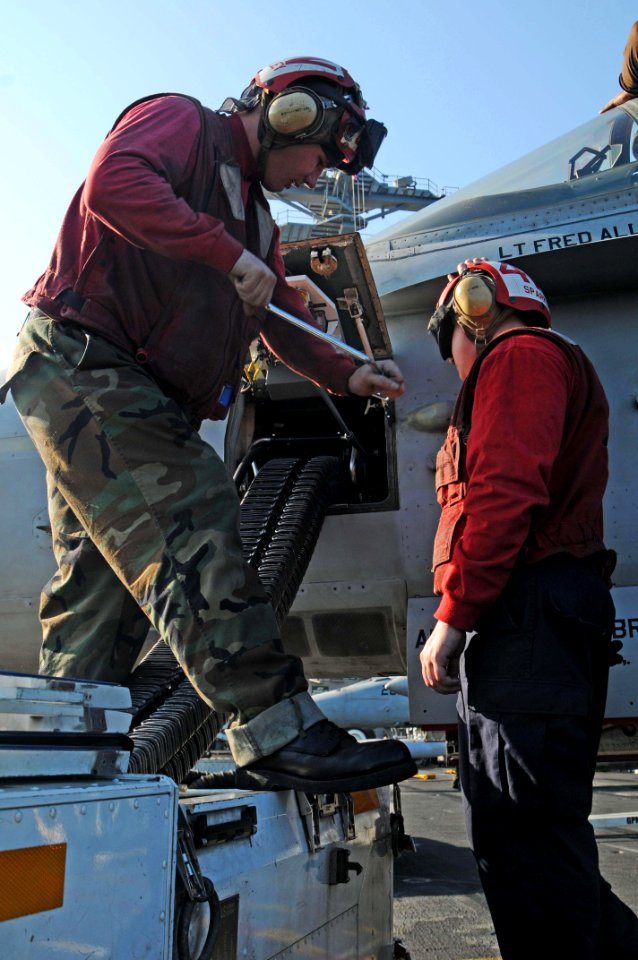 US Navy 091207-N-3038W-609 Aviation Ordnanceman Airman Daniel Huntley and Aviation Ordnanceman 3rd Class Nigel Sparks, assigned to the Sidewinders of Strike Fighter Squadron (VFA) 86, upload 20mm machine gun rounds to an F-A-18