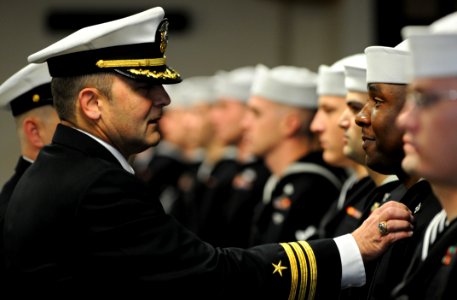 US Navy 091204-N-5328N-914 Commander Frank Shaul adjusts the ribbons of Cryptology Technician (Networks) 2nd Class Brandon Johns during a command uniform inspection