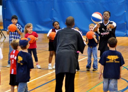 US Navy 091206-N-2013O-017 Lade Majic, Harlem Ambassadors basketball team coach and player, demonstrates proper passing techniques to children during a basketball camp sponsored by Yokosuka Morale, Welfare and Recreation Youth