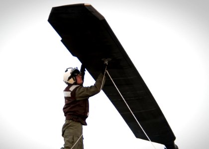 US Navy 091206-N-5712P-010 Cpl. Devan LeBlanc ties down a helicopter blade in preparation for stowing the aircraft aboard the amphibious assault ship USS Nassau (LHA 4) photo