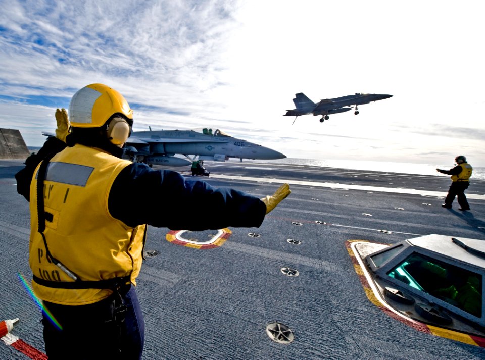 US Navy 091210-N-2953W-001 Aviation Boatswain's Mate 1st Class Jorge Agostini directs a team member on the flight deck of USS Carl Vinson (CVN 70)