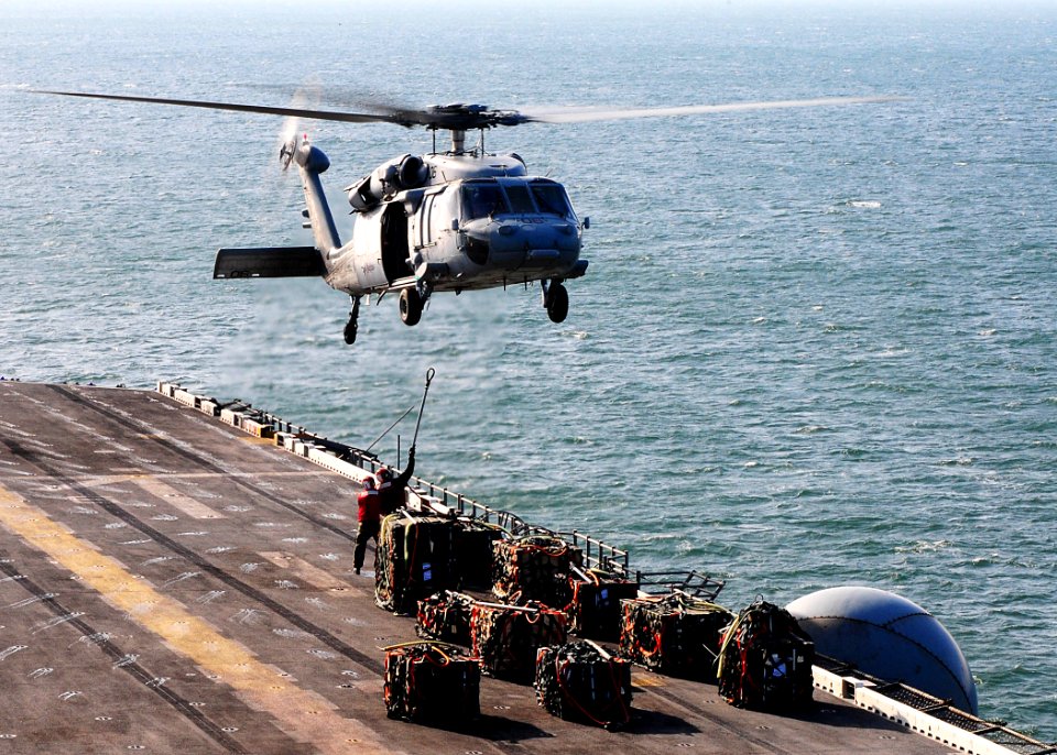 US Navy 091206-N-8655E-003 An MH-60S Sea Hawk helicopter assigned to Helicopter Sea Combat Squadron (HSC) 28 prepares to transfer ammunition from multipurpose amphibious assault ship USS Bataan (LHD 5) to amphibious assault shi