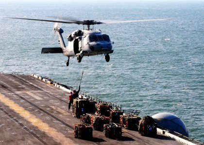 US Navy 091206-N-8655E-003 An MH-60S Sea Hawk helicopter assigned to Helicopter Sea Combat Squadron (HSC) 28 prepares to transfer ammunition from multipurpose amphibious assault ship USS Bataan (LHD 5) to amphibious assault shi