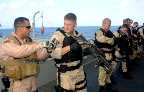 US Navy 091209-N-1291E-050 Members of the visit, board, search and seizure team of the guided-missile cruiser USS Chosin (CG 65) practice transition drills from their primary to secondary weapons photo