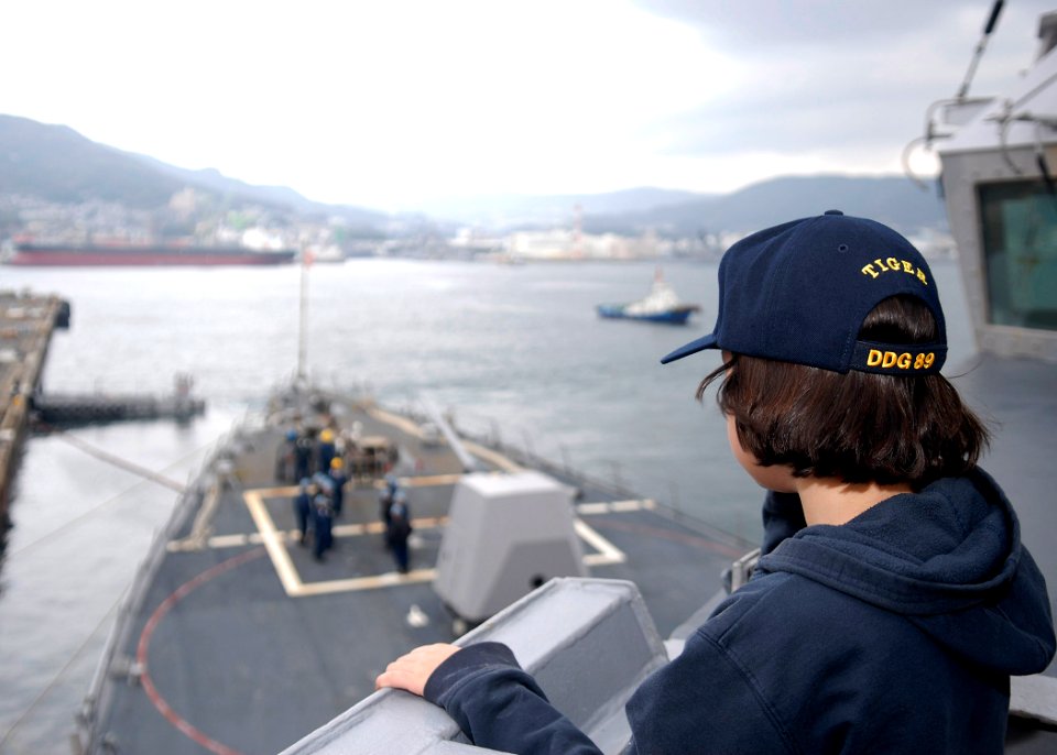 US Navy 091212-N-9520G-066 A family member looks on as Sailors assigned to the Arleigh Burke-class guided-missile destroyer USS Mustin (DDG 89) gets underway for a Tiger Cruise