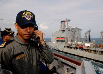 US Navy 091206-N-9520G-035 Royal Malaysian Navy Sub Lt. Amir Potera Bin Omar gives orders to the helmsman as the guided-missile destroyer USS Mustin (DDG 89) conducts a replenishment at sea