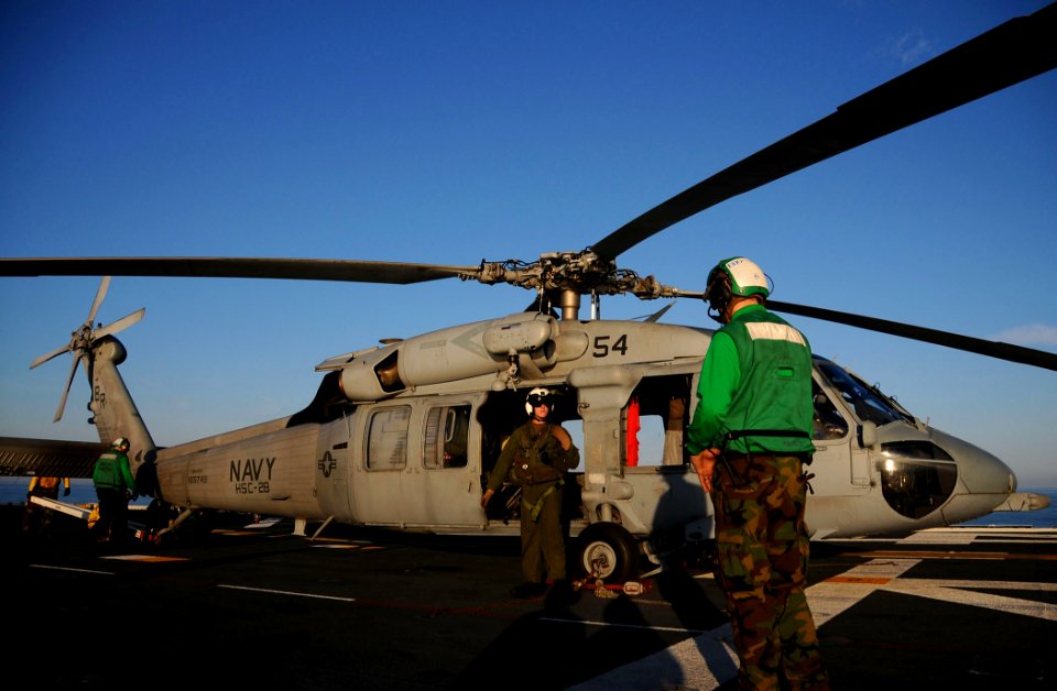 US Navy 091214-N-2735T-063 Aviation Machinist's Mate 2nd Class William K. Childree speaks with an air crewman of an MH-60S Sea Hawk helicopter
