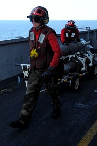 US Navy 091207-N-3038W-666 Sailors assigned to the Black Aces of Strike Fighter Squadron (VFA) 41 transport ordnance to aircraft aboard the aircraft carrier USS Nimitz (CVN 68)
