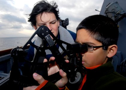 US Navy 091214-N-9520G-324 Quartermaster Seaman Samantha R. Elwell teaches the son of Cmdr. Michael Misiewicz istance and position using a stadimeter