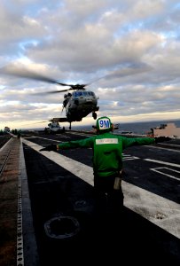 US Navy 091208-N-9928E-144 Aviation Structural Mechanic 3rd Class Tyler Clausen signals an MH-60S Sea Hawk helicopter aboard USS John C. Stennis (CVN 74)