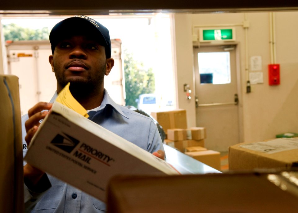 US Navy 091213-N-5253W-005 Logistics Specialist 3rd Class David Robinson retrieves packages for customers at the post office at Commander Fleet Activities Yokosuka