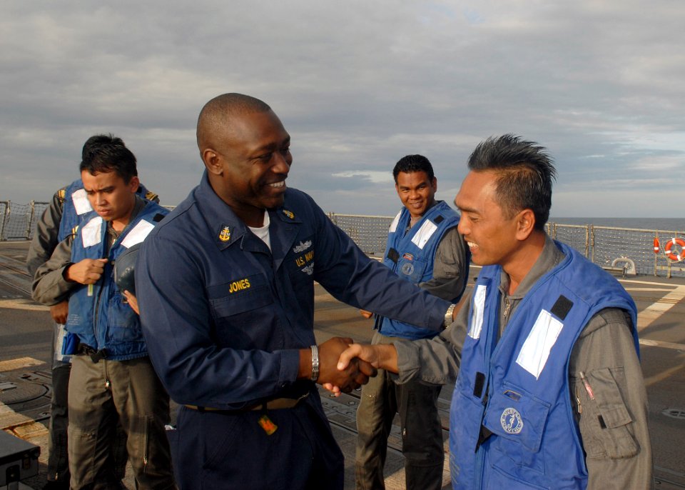 US Navy 091208-N-9520G-223 Senior Chief Culinary Specialist David Jones, assigned to the guided-missile destroyer USS Mustin (DDG 89), bids farewell to sailors from the Royal Malaysian Navy