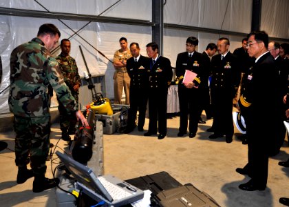 US Navy 091208-N-2013O-033 Sonar Technician (Surface) 2nd Class John Anderson explains the functions of the REMUS 100 unmanned underwater vehicle to Rear Adm. Kouichirou Matsumoto