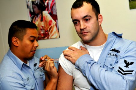 US Navy 091214-N-1251W-016 Hospital Corpsman 2nd Class Eric Pacheco administers the H1N1 flu vaccine to Interior Communications Electrician 2nd Class Stuart Ringrose