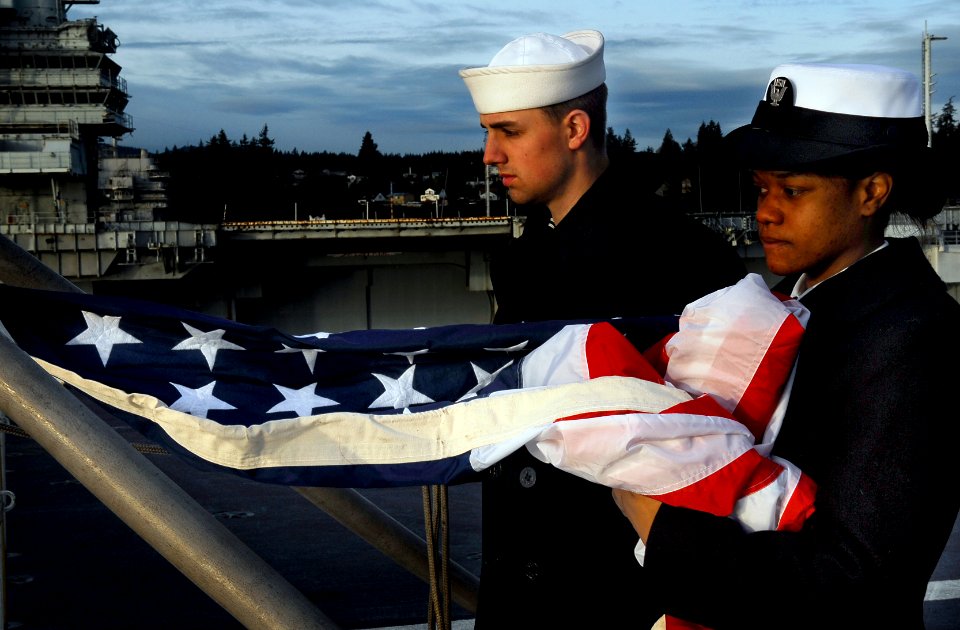US Navy 091218-N-6046S-055 Sailors prepare to hoist the national Ensign on the stern of the Nimitz-class aircraft carrier USS John C. Stennis (CVN 74)