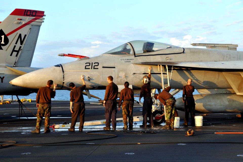 US Navy 091218-N-8421M-054 Sailors assigned to the Tophatters of Strike Fighter Squadron (VFA) 14 wash an F-A-18E Super Hornet