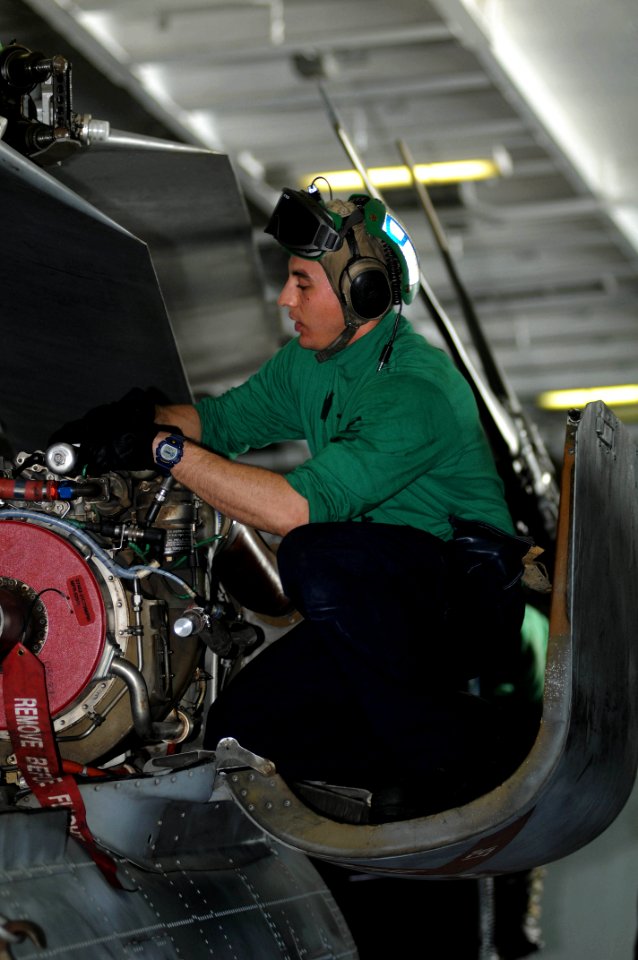 US Navy 091212-N-3038W-097 viation Electrician's Mate 2nd Class Matthew Dimaline performs maintenance on an SH-60F Sea Hawk helicopter