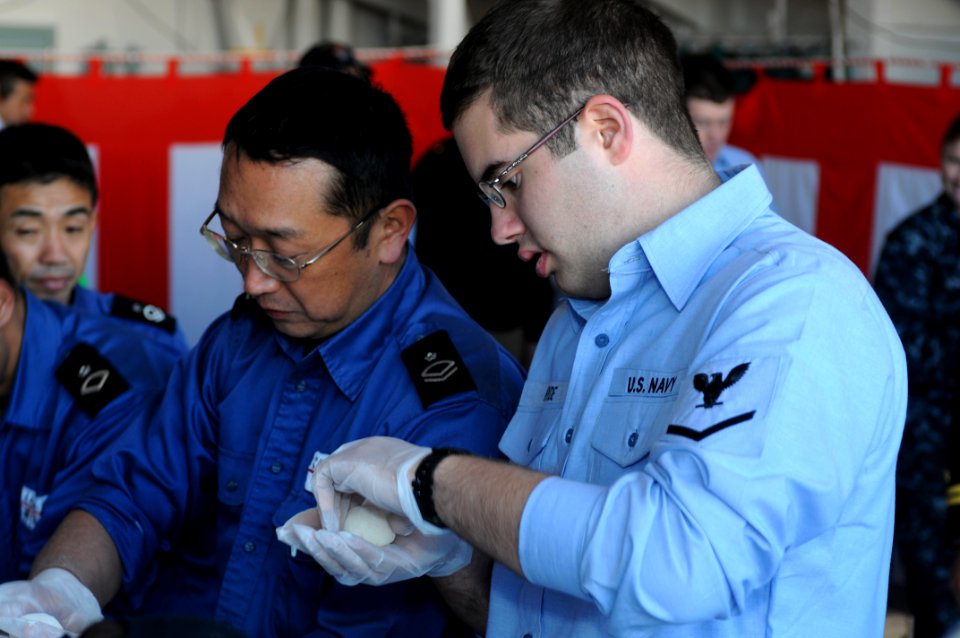 US Navy 091214-N-0120A-104 Information Specialist 3rd Class Joseph Hyde and Japan Maritime Self-Defense Force sailors shape a ball of mochi