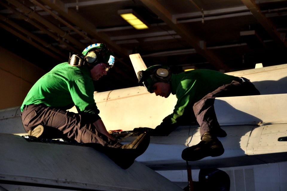 US Navy 091225-N-8421M-128 Aviation Electrician's Mate 2nd Class Andrew Savini and Aviation Electrician's Mate Airman Dexter Fredinburg conduct maintenance on an F-A-18C Hornet