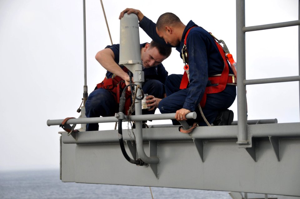 US Navy 091218-N-8421M-025 Electronics Technician 3rd Class Jay Swing and Electronics Technician 3rd Class Todd Reck perform maintenance on an antenna