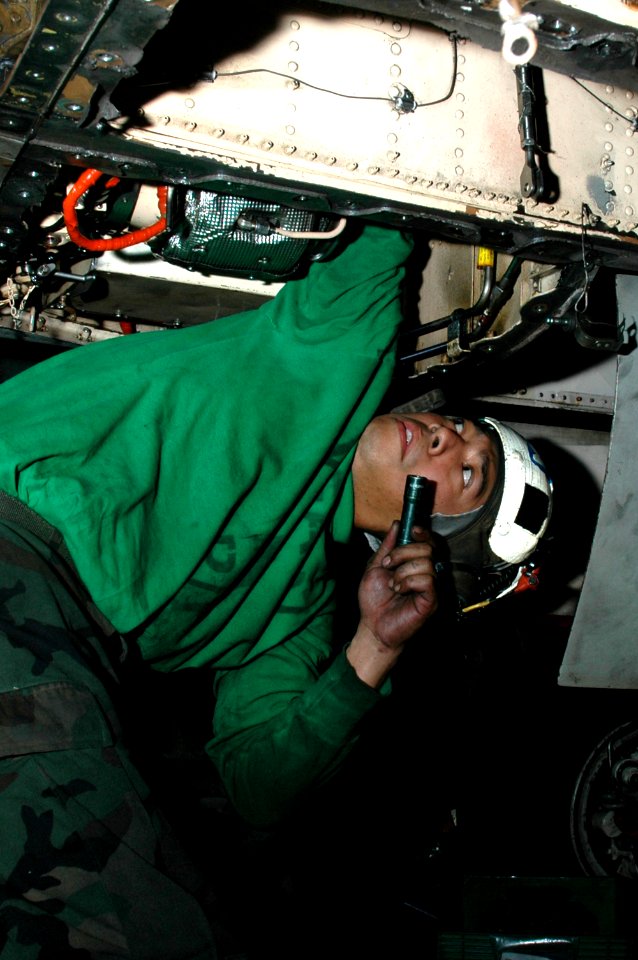 US Navy 091214-N-3327M-045 Aviation Machinist's Mate 2nd Class Raynard Eugenio performs maintenance on an F-A-18C Hornet