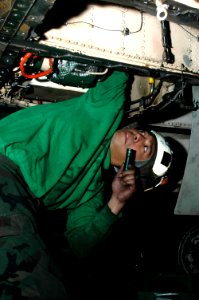 US Navy 091214-N-3327M-045 Aviation Machinist's Mate 2nd Class Raynard Eugenio performs maintenance on an F-A-18C Hornet photo