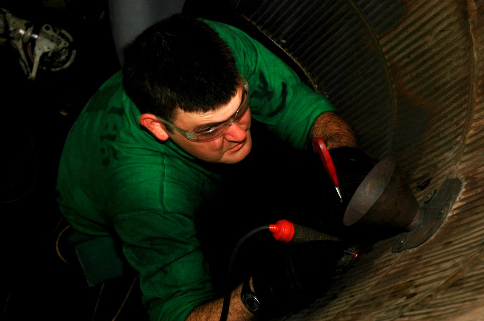 US Navy 091212-N-3327M-010 Aviation Machinist's Mate 3rd Class Bryan Katzenmeyer tack welds a mid-engine bay door on an EA-6B Prowler