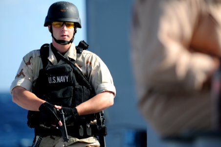 US Navy 091213-N-0260R-022 A member of the visit, board, search and seizure team posts security while the rest of the team conducts a mock clearing of a vessel