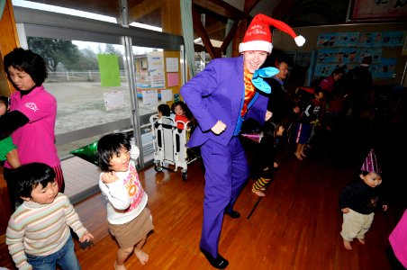 US Navy 091218-N-8335D-232 Master-at-Arms 3rd Class Paul Ellis dances with children at the Kusuzumi daycare center