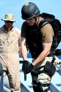 US Navy 091215-N-0260R-012 A visit, board, search and seizure team member provides security on a hatch in the deck while the rest of the team clears a mock vessel during a training evolution aboard the guided-missile cruiser US