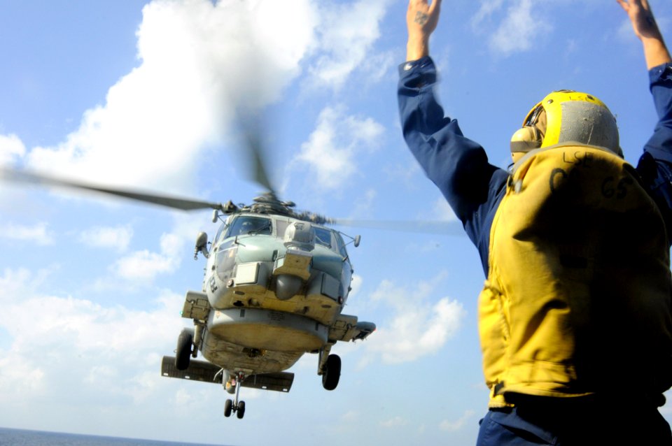 US Navy 100105-N-1291E-056 Boatswains Mate 3rd Class Nicholas Valle directs an SH-60 Seahawk helicopter assigned to Helicopter Anti-Submarine Squadron Light (HSL-37) during a vertical replenishment aboard the guided-missile cru