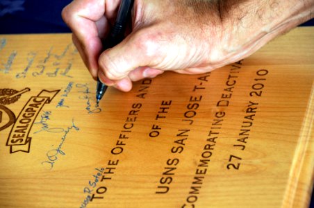 US Navy 091218-N-7498L-308 Capt. Jerome Hamel, commander of Sealift Logistics Command Pacific, signs his name as a witness to the decommissioning ceremony of the Military Sealift Command combat stores ship USNS San Jose