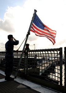 US Navy 100105-N-1429M-025 Gunner's Mate 2nd Class Marc Gomez salutes the national ensign during the shifting of colors