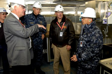 US Navy 091221-N-4482V-010 Rear Adm. Joseph Kilkenny, commander of Naval Education and Training, and Richard L. James, executive director of Naval Education and Training Command, discuss the galley configuration with Chief Stor