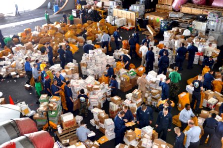 US Navy 091224-N-8421M-006 Sailors aboard the aircraft carrier USS Nimitz (CVN 68) sort through 34,400 pounds of mail delivered Christmas Eve