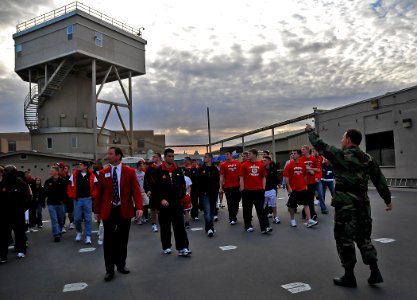 US Navy 091228-N-4774B-075 Athletes and staff of the University of Nebraska football team pass by a five-story dive tank during a guided tour of Naval Special Warfare Center, Navy SEALs training facility