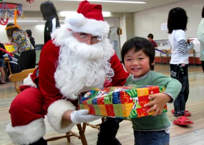 US Navy 091220-N-XXXXX-001 Petty Officer 1st. Class James Durrance acts as Santa during a visit to distribute toys to children of the Misono Orphanage photo