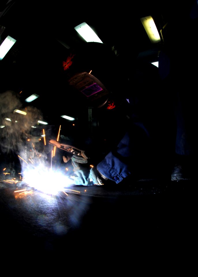 US Navy 100104-N-4236E-277 Hull Technician 3rd Class Colleen English welds pieces of a rack together