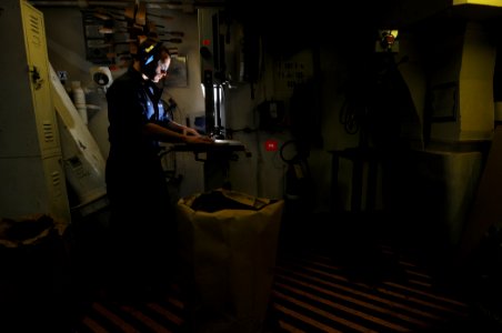US Navy 100104-N-1688B-018 Hull Technician 3rd Class Elijah Coe uses a band saw to cut out wooden plaques
