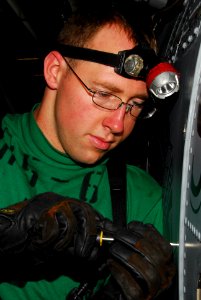 US Navy 100104-N-3327M-069 Matt Huneycutt installs an electrical cover on an SH-60F Sea Hawk helicopter
