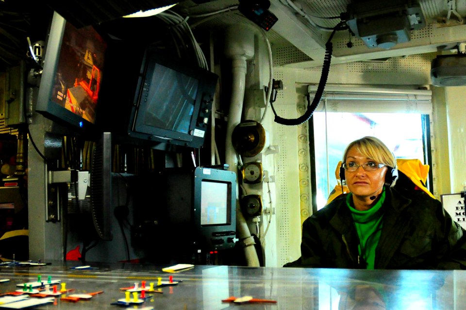 US Navy 100112-N-7939W-011 Lt. Regina Rogers, the Navy's first female aircraft handler, coordinates movements on the flight deck during flight operations aboard