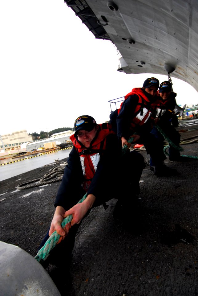 US Navy 100106-N-2475A-098 Sailors heave a line to move a barge along the port side of the Nimitz-class aircraft carrier USS John C. Stennis (CVN 74)