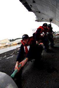 US Navy 100106-N-2475A-098 Sailors heave a line to move a barge along the port side of the Nimitz-class aircraft carrier USS John C. Stennis (CVN 74)